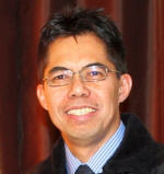 A person wearing glasses and a black coat